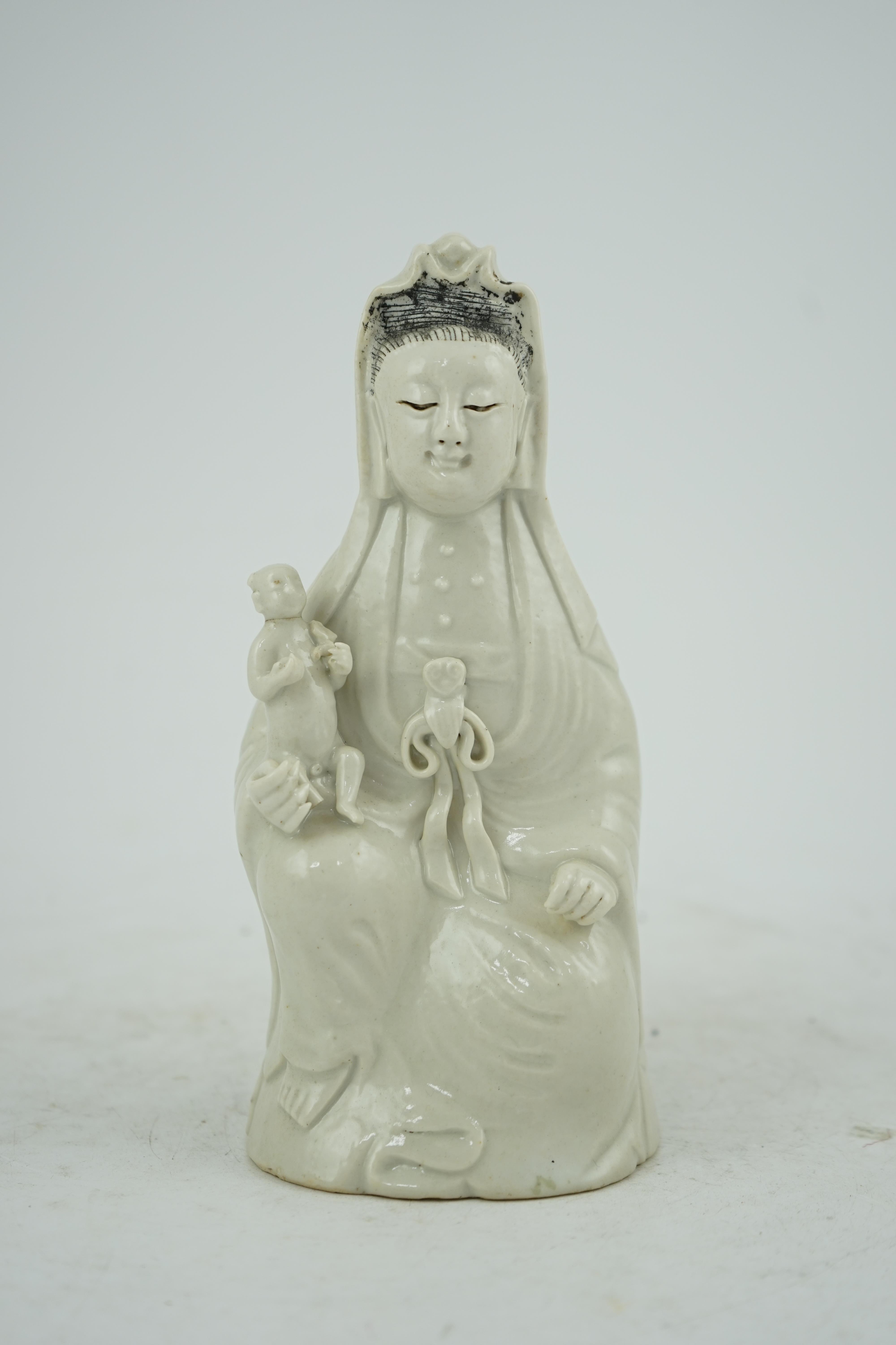 A Chinese white glazed group of Guanyin and child, 18th/19th century